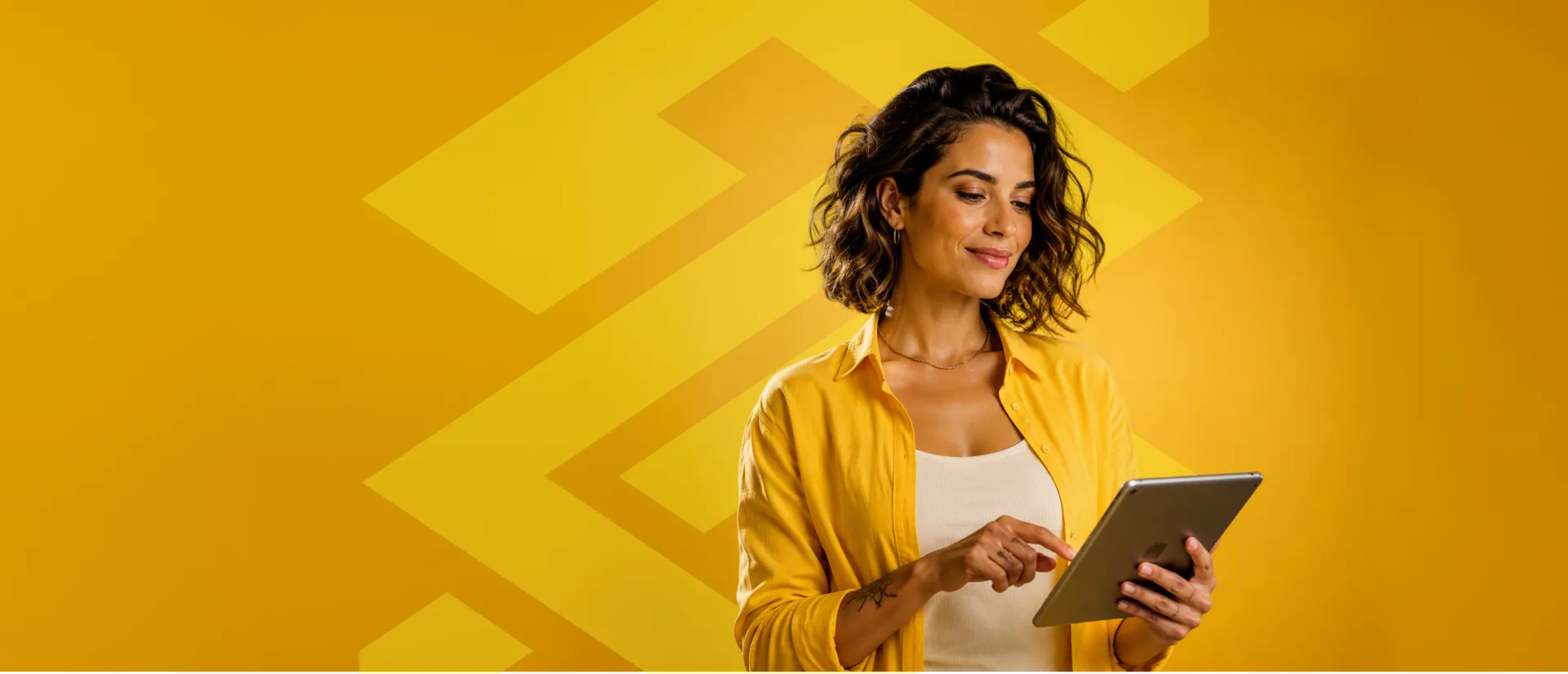 Mulher de camisa amarela olhando para o tablet
