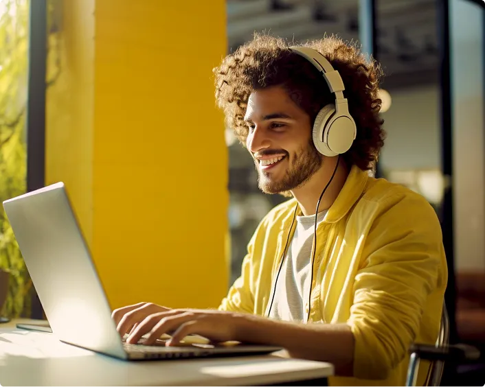 Homem com camisa amarela digitando no computador